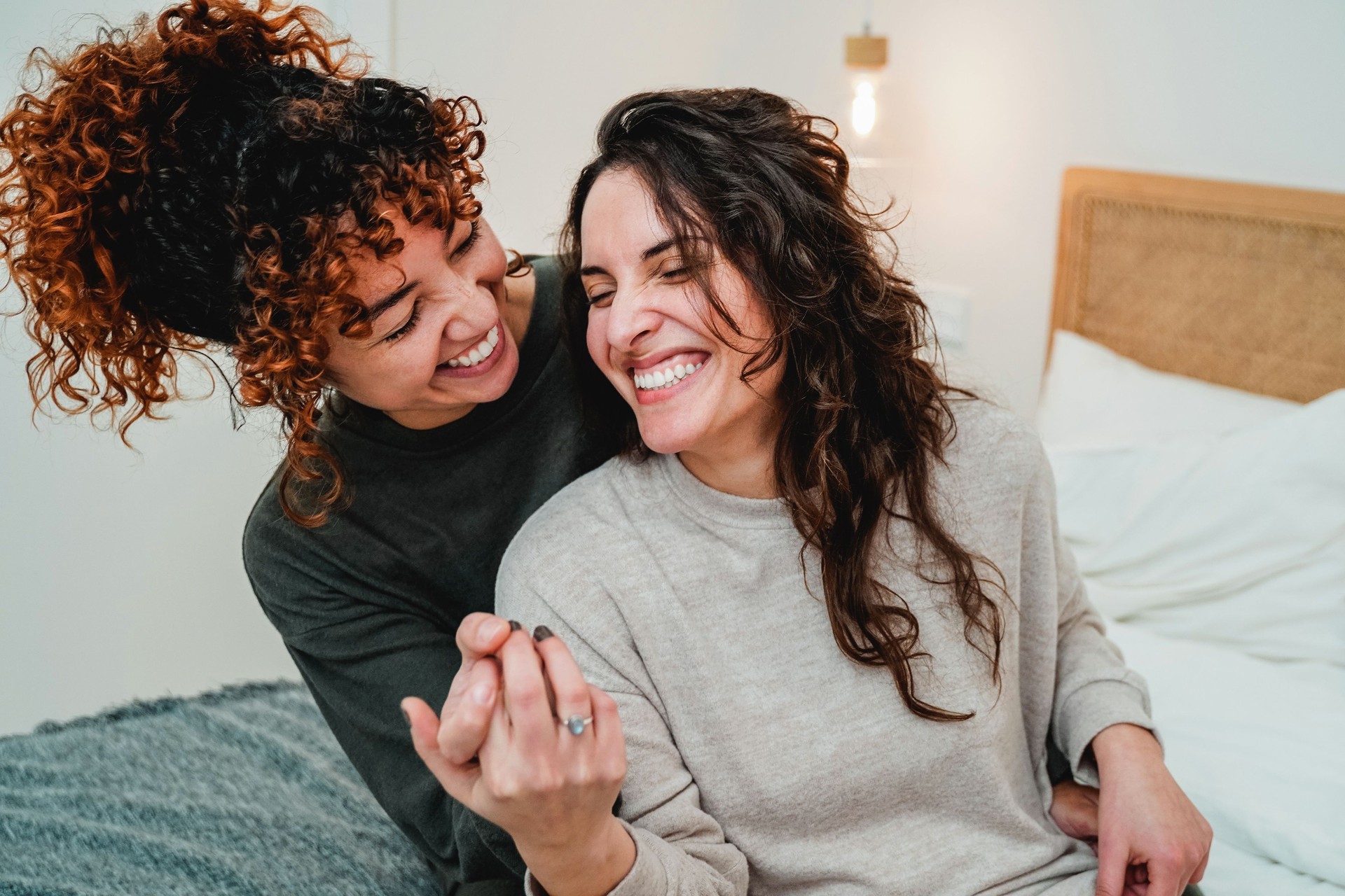 Feliz pareja de mujeres gay celebrando juntos con anillo de compromiso en la cama - Enfoque suave en la cara correcta de la chica lesbiana